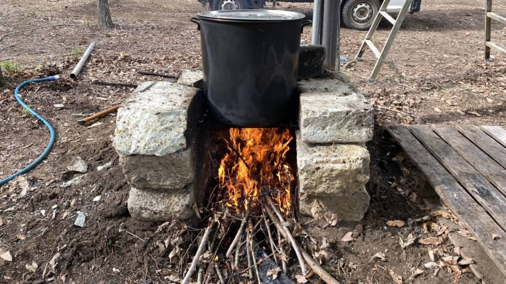 大鍋を使って焚火でゆで上げます